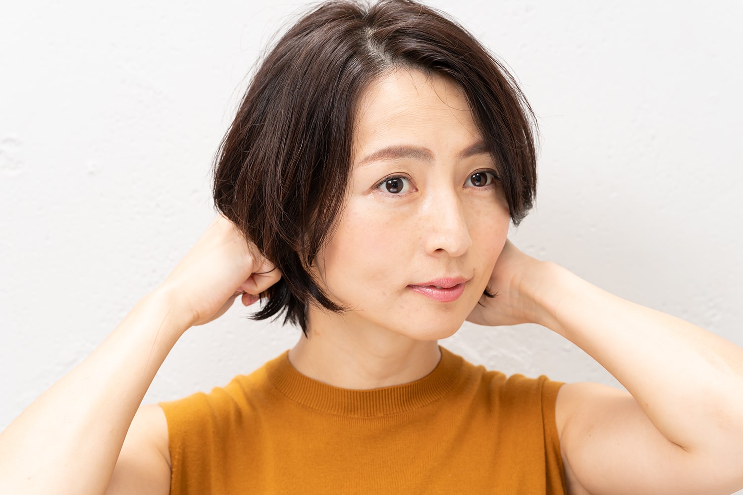 襟足部分の根元は広がらないように抑え、毛先だけ動きを付ける。