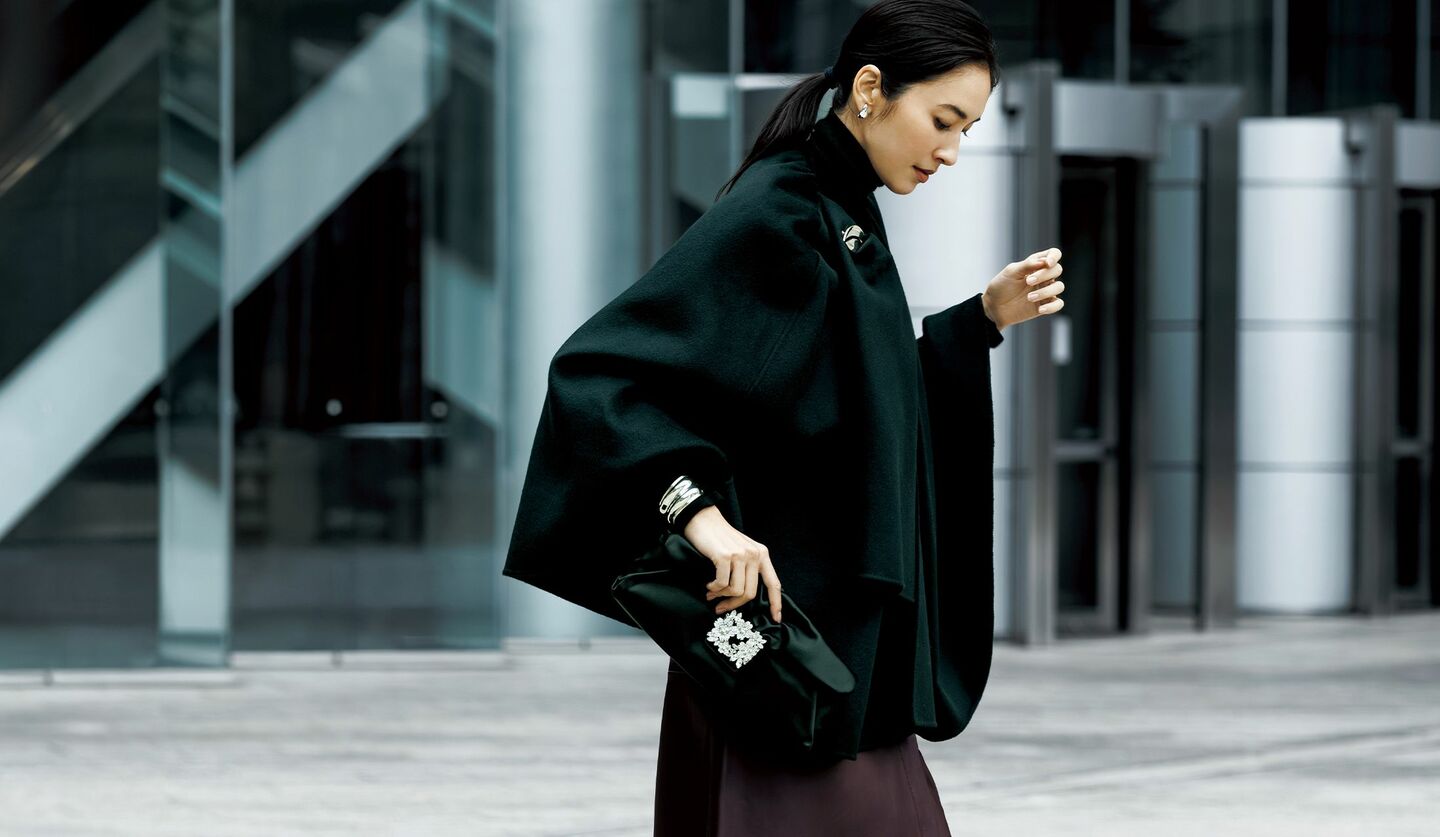 ブラックのショート丈マントを着用したモデル