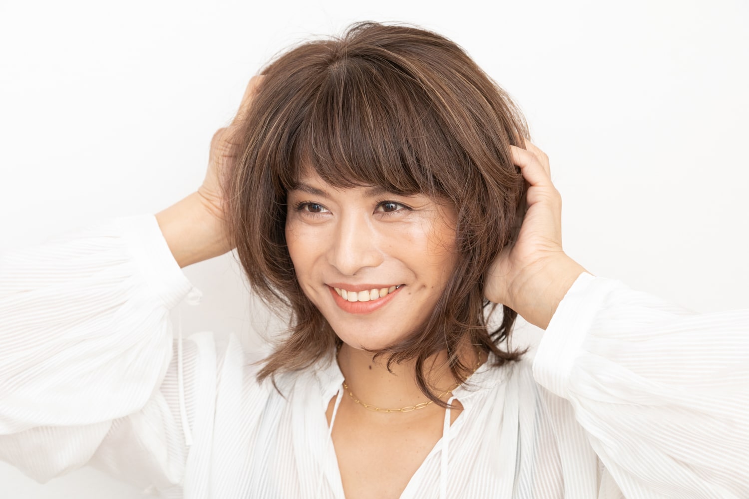 柔らかめのバームタイプのスタイリング剤を手のひらにのばし、髪全体にもみ込む。潤いを与え、柔らかな動きを出す。