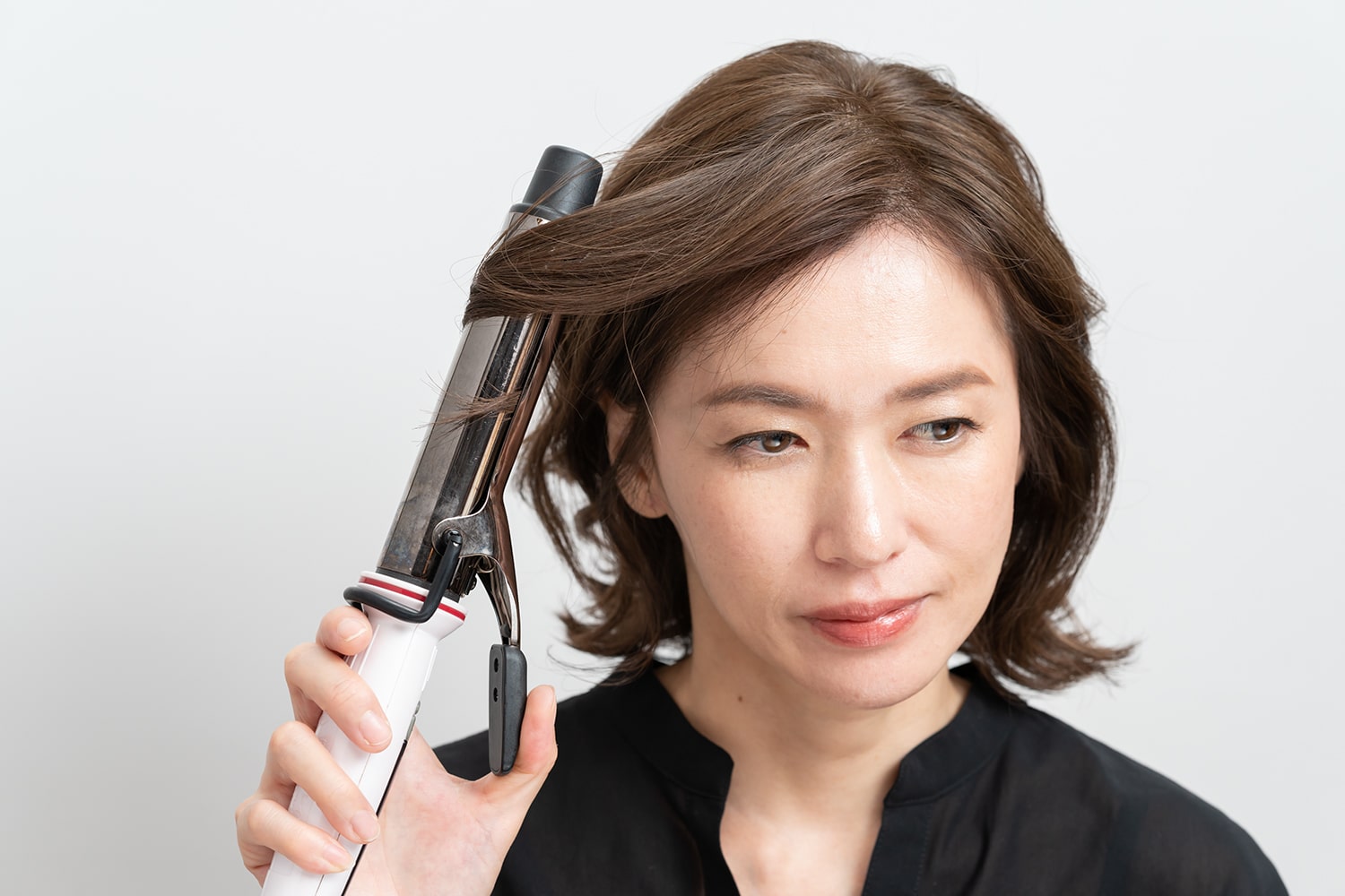毛束の中間から毛先に向かってリバース巻きに。