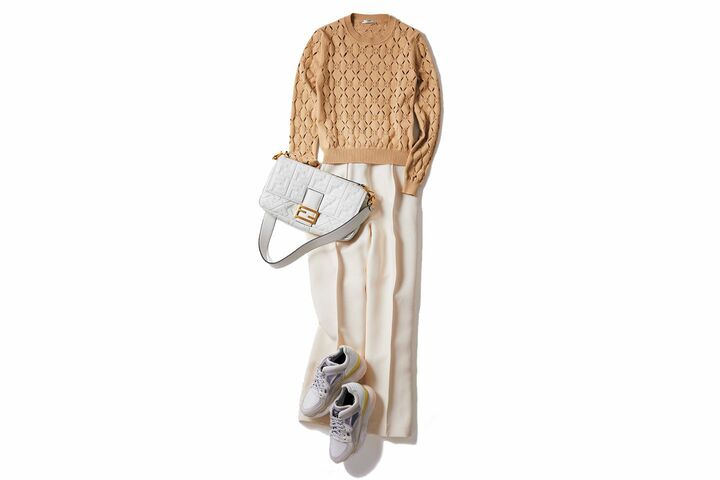 クリーミー配色のニットとパンツに白のスニーカーを合わせてリッチなカジュアルスタイルに。エンボスロゴの大きめ「バゲット」で上品な遊び心を演出。バッグ「バゲット」ラージ￥333,000【サイズ：縦18×横33×マチ5.5cm】［ナッパレザー］・ニット￥95,000・パンツ￥135,000・靴￥110,000（フェンディ ジャパン）