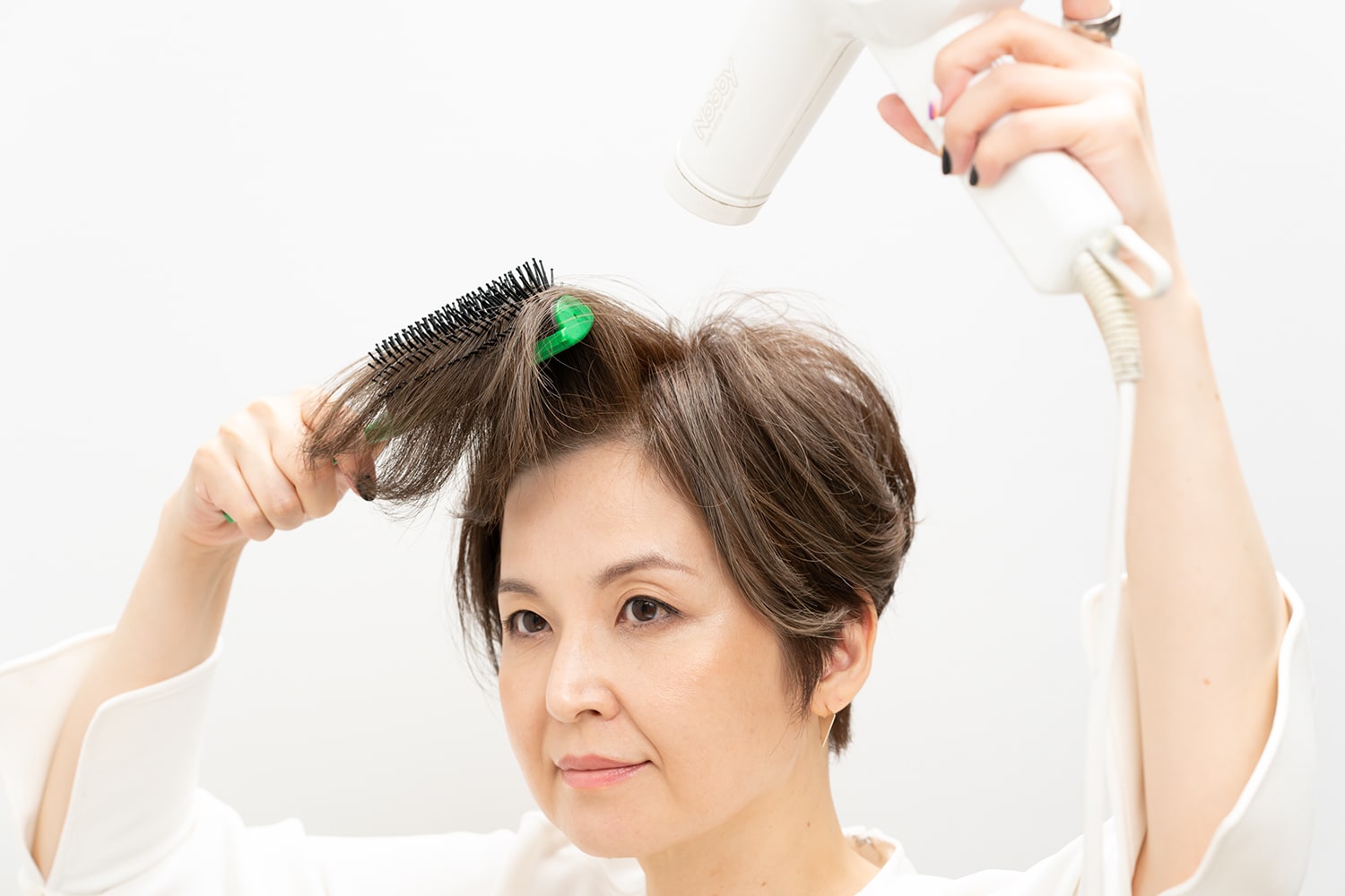ブラシを下から持ち上げるように、ブローしながらドライヤーを当てます。この時に根元ではなく、毛束の中間に丸みをつけるように意識して。