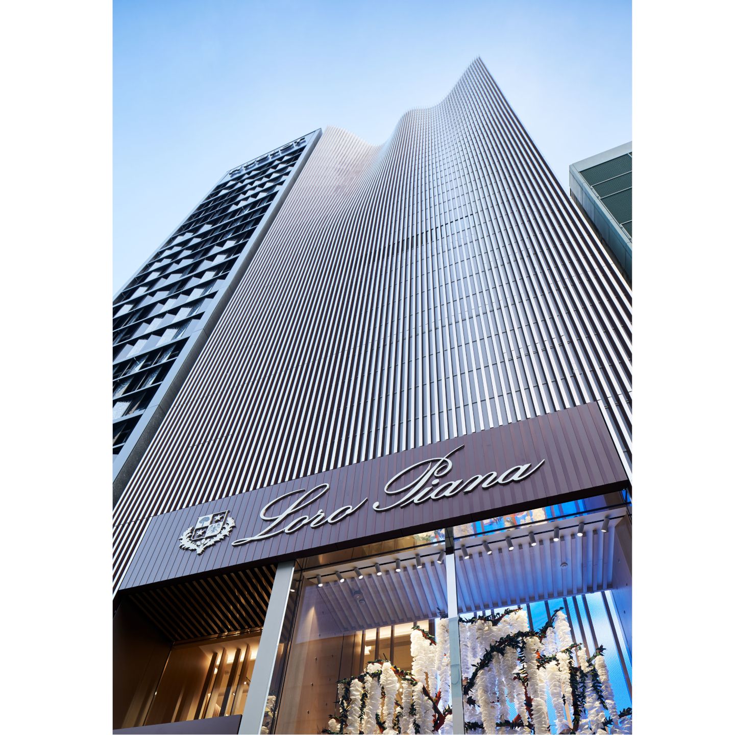 ロロ・ピアーナ旗艦店は、虹色の光沢を放ちながら上に向かって薄くなるグラデーションと流麗なラインが目を引く、モダンな外観