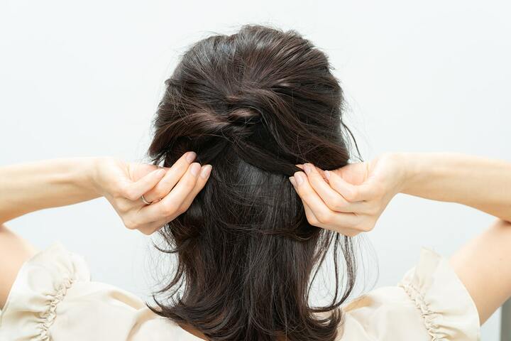 毛束の結び目が緩まないように、毛束を左右に引っ張る。