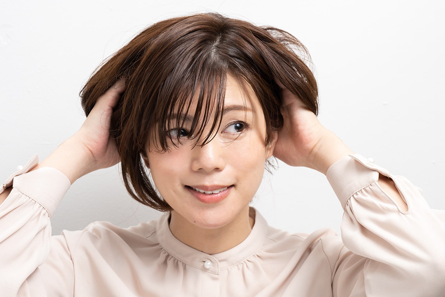 毛先の軽やかさを出すためにクリームタイプのスタイリング剤をなじませる。