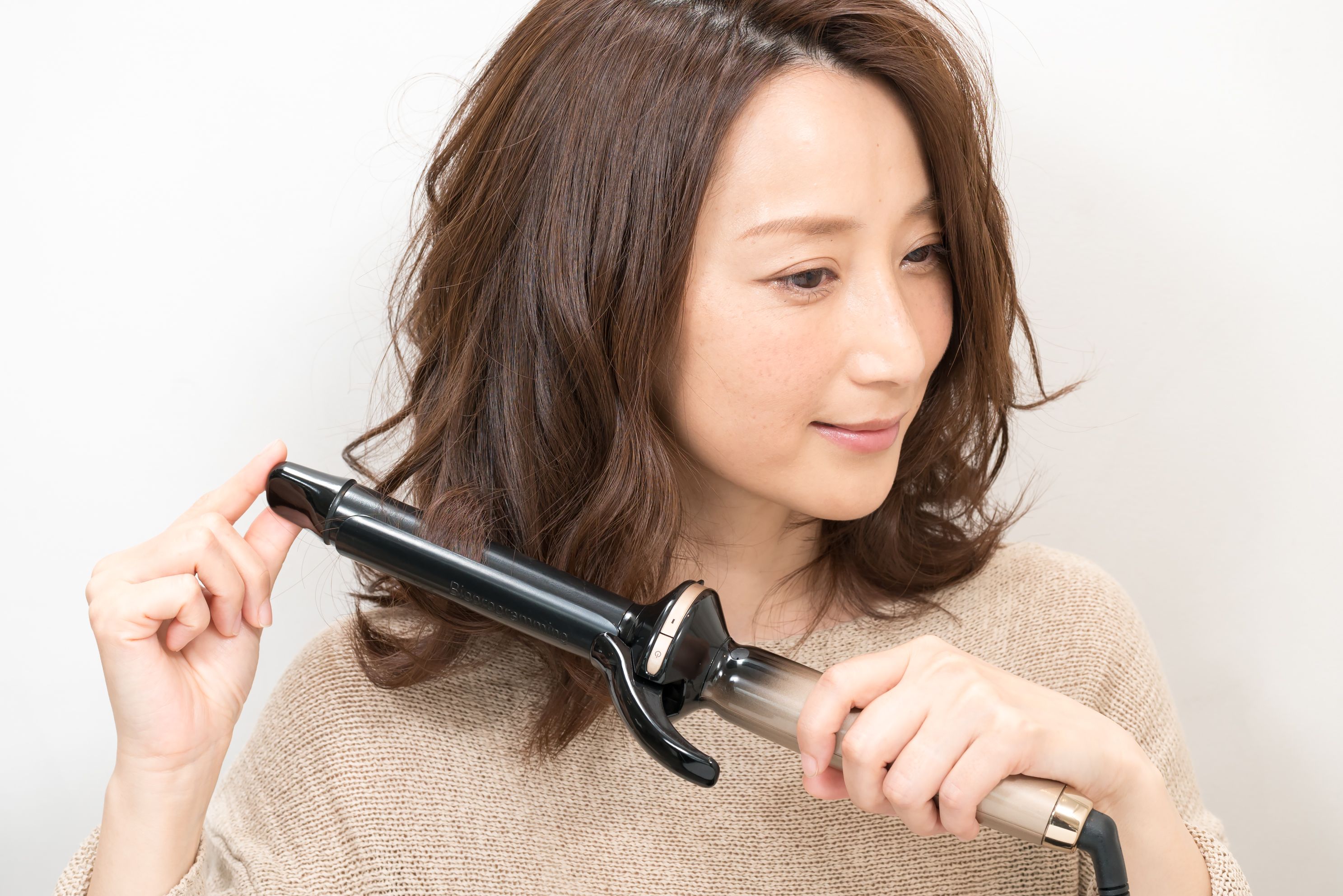 アイロンは25mmを使用。毛束を細く取って、内巻き、外巻きとランダムに巻いていく。