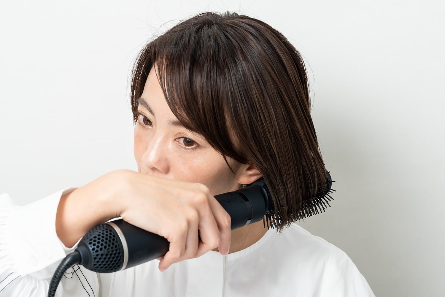 くるくるドライヤーで髪を軽く引っ張りながら毛先を内巻きに。