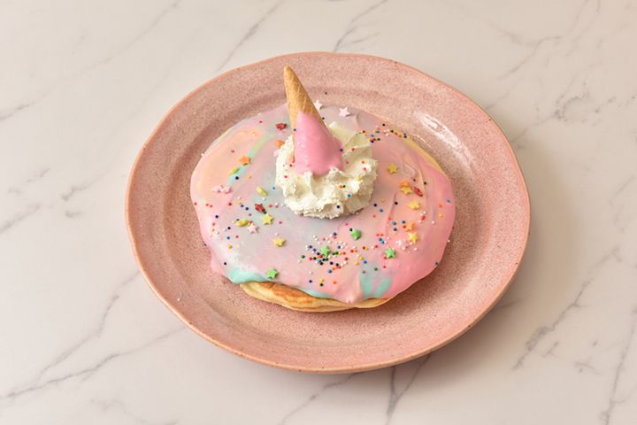 カラフルなユニコーンカラーのコンデンスミルクソースとコーンの一角がかわいい、フォトジェニックな「ユニコーンパンケーキ」(¥1480)も人気