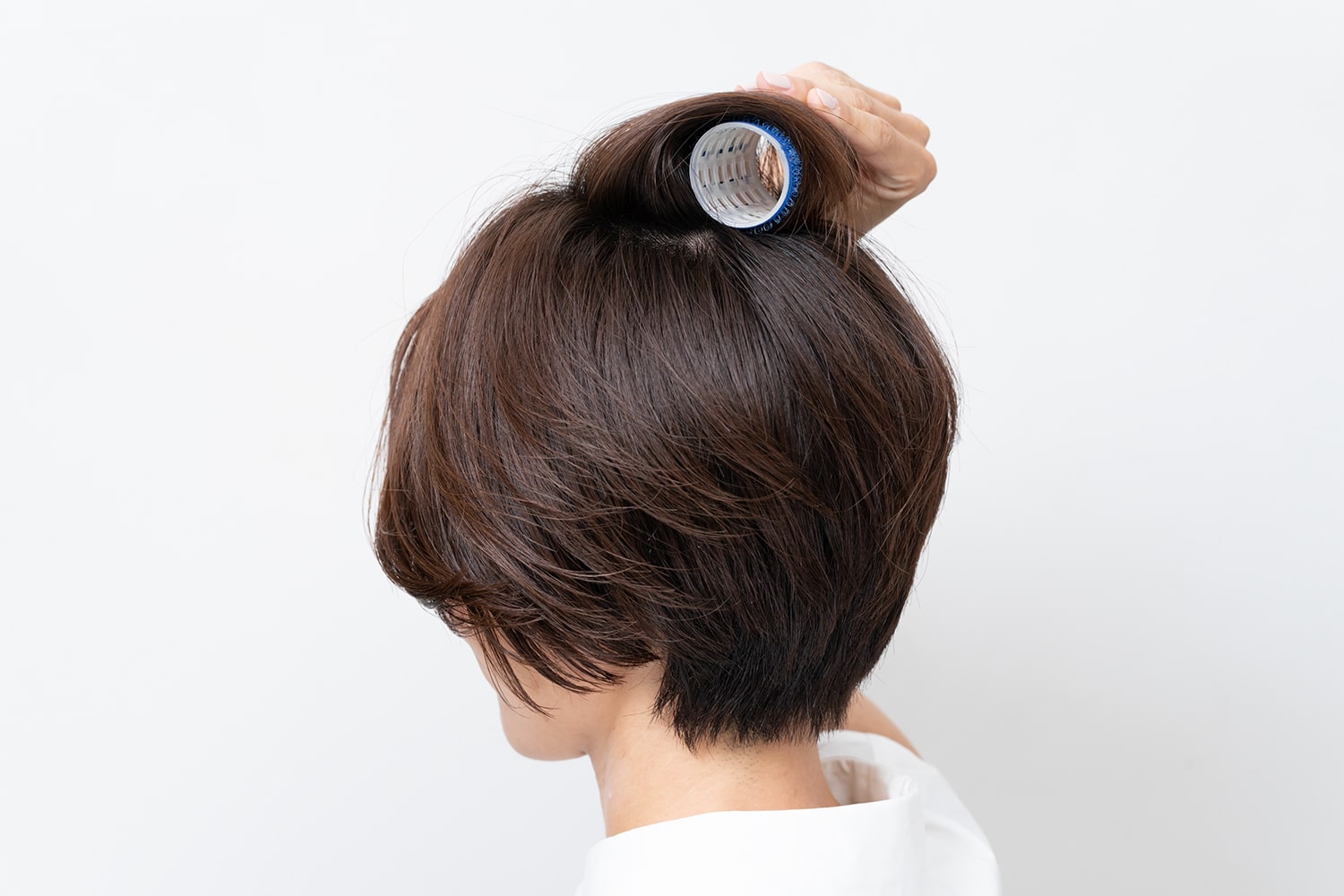 毛先から根元までしっかりと巻き込むとトップにふんわりとしたボリュームが生まれる。巻いたら10〜15分放置して。