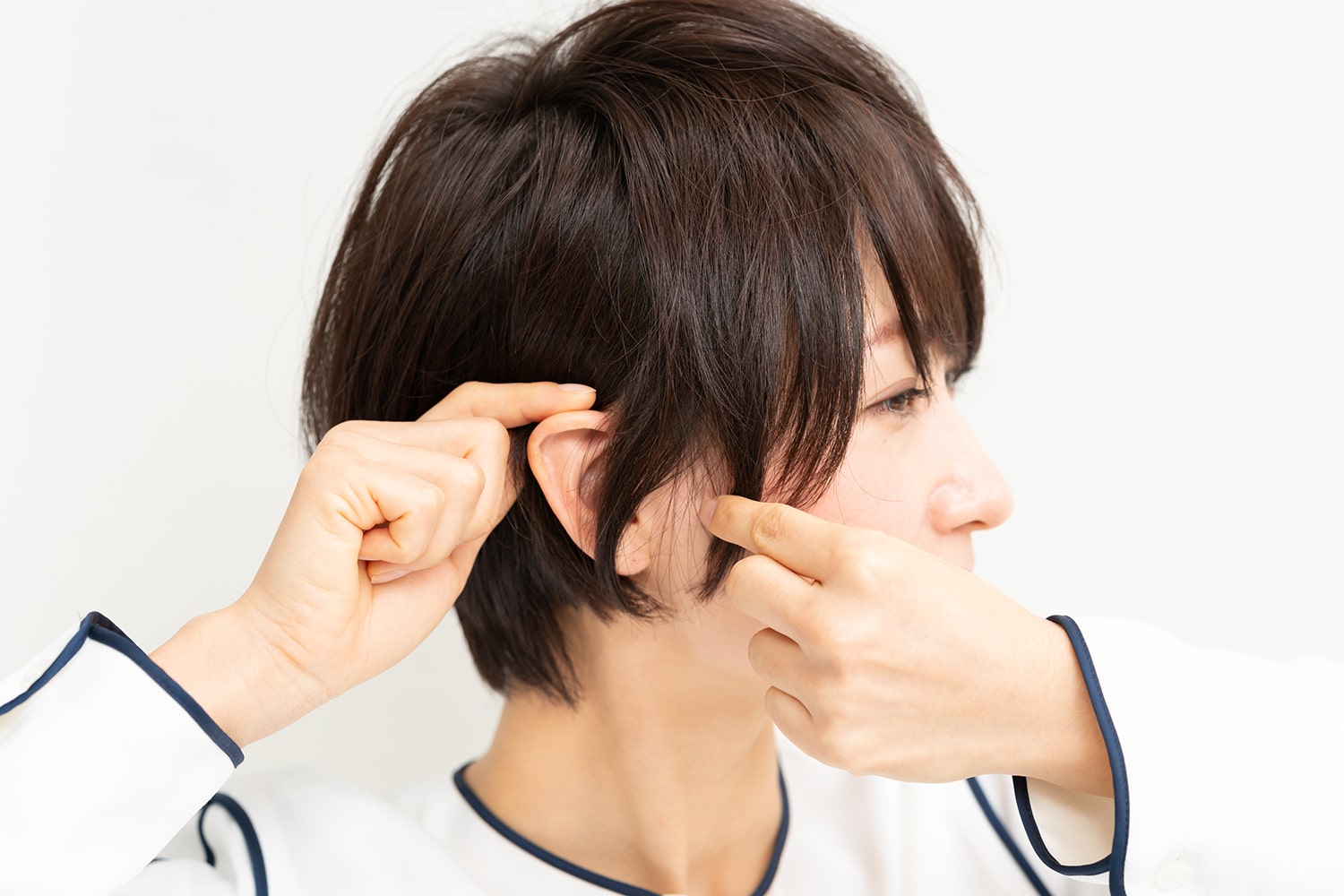 耳上の毛を耳にかけたら、耳前の毛はつまんで束感を出す。
