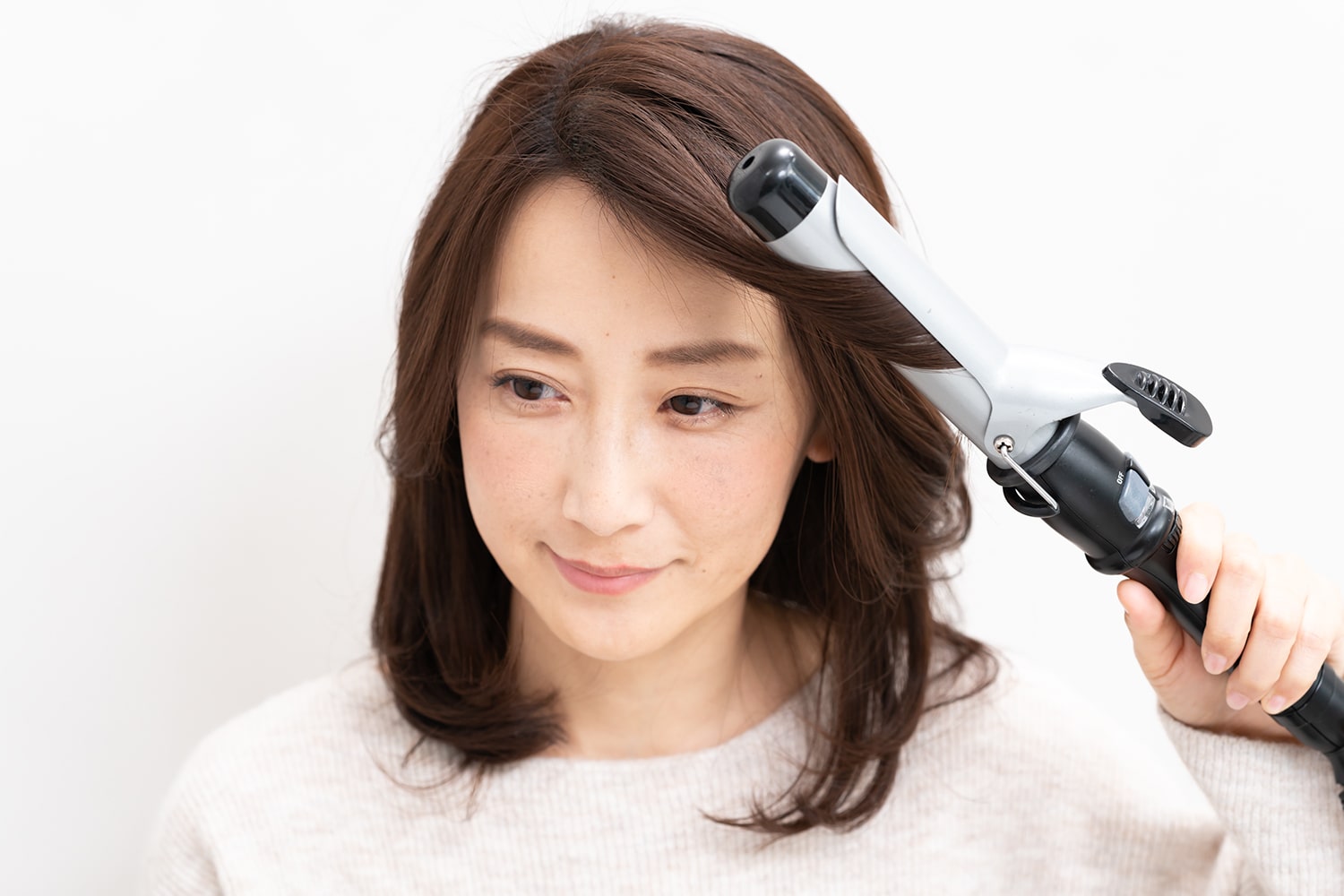 毛束の中間から毛先をワンカール。逆サイドの前髪も同様にすると菱形フォルムに。