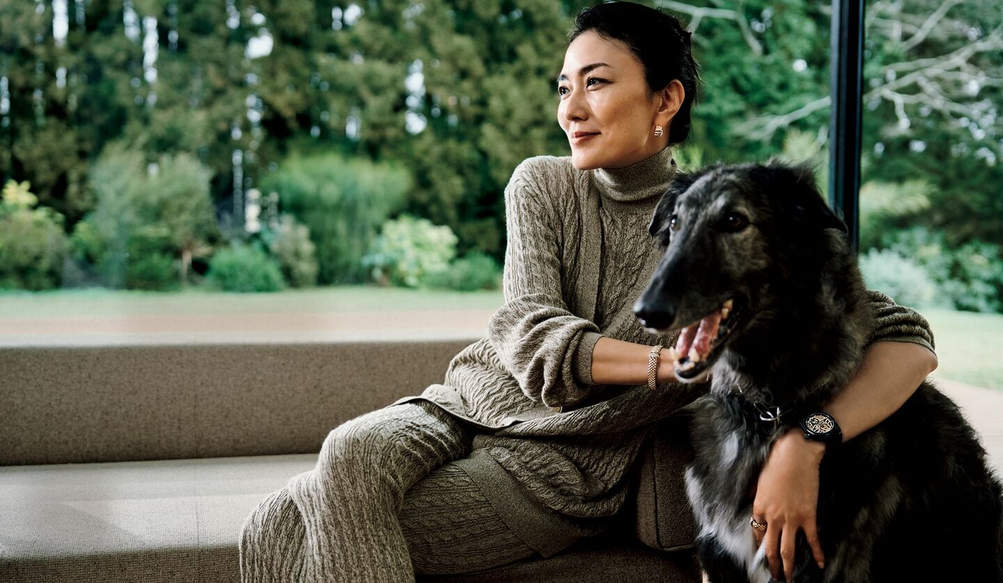 俳優の板谷由夏さんと犬のアキーラがロロ・ピアーナの極上ニットウエアと、「ゼニス」のスケルトンウォッチを着用した画像