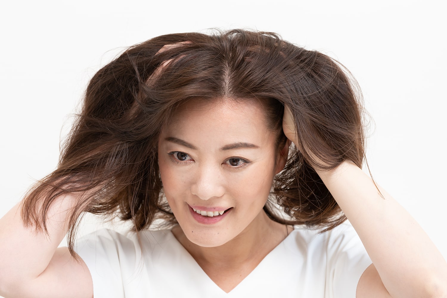 パール1粒大くらいのワックスを手のひらになじませて、髪の内側から大胆に揉み込んで。