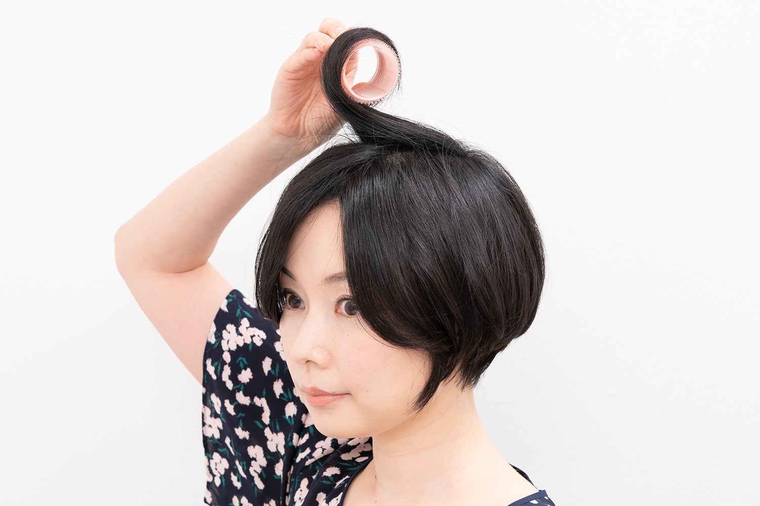 毛先からカーラーに巻き付けるとき、毛束の根元を前傾させるイメージで巻くのがポイント。
