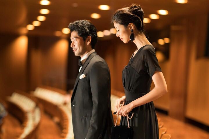 左・男性／タキシード¥812,000・シャツ¥108,000・チーフ¥18,000・ボウタイ¥18,000・靴¥123,000（ブリオーニ ジャパン／ブリオーニ）
右・女性／ロングドレス¥620,000・イヤリング［参考価格］¥45,000・バッグ［参考価格］¥185,000・靴［参考価格］¥105,000（ジョルジオ アルマーニ ジャパン／ジョルジオ アルマーニ）