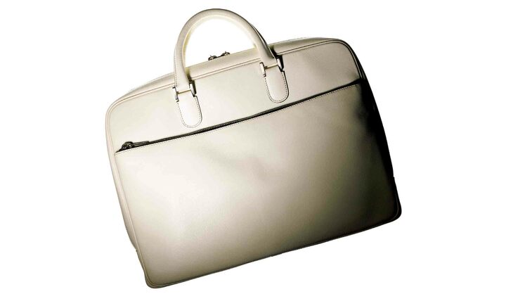 ブランド定番の型押しレザー「ソフト・カーフスキン」を採用したブリーフケースは、やわらかさとハリ感を兼ね備え、持ったときのフォルムが実に美しい。［名品データ］●モデル名：『ダブルハンドルブリーフケース』 ●素材：カーフ ●サイズ：縦30×横41×マチ８cm ●色展開：写真のホワイトのほか、ダークグレー、オイスターグレー、レッド、コバルトブルー、ロイヤルブルー、ネイビーもあり ￥285,000（ヴァレクストラ・ジャパン）※税抜、参考価格