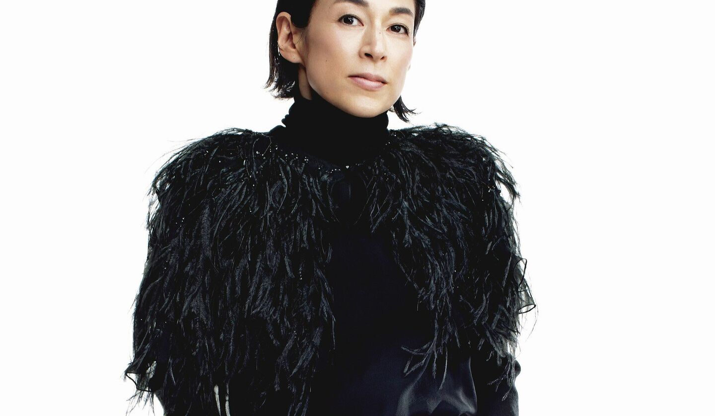 黒タートルに黒のフェザーを羽織った鈴木保奈美さんの写真