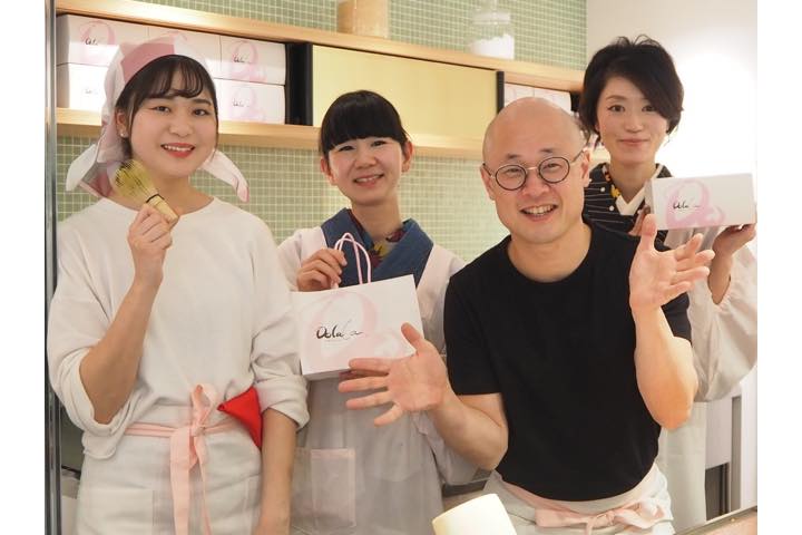 お店のスタッフと松村さん。可愛いテイクアウト専用バッグと箱でお持ち帰りにも対応しています。