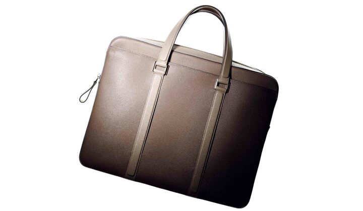 直線はあくまで精悍に、曲線はとびきり優雅に……。そんなデザイン哲学がうかがえる、美しいブリーフケース。高い機能性をことさらに主張しない点にも、名門のプライドがうかがえる。［名品データ］●モデル名：『ニュースペーパーⅡ』 ●素材：カーフ ●サイズ：縦30.5×横38.5×マチ６cm ●色展開：写真のアイボリーのほか、ブラック、ブラウンがあり ●その他：取り外し可能なショルダーストラップが付属 ￥324,000（デルヴォー 表参道）※税抜、参考価格