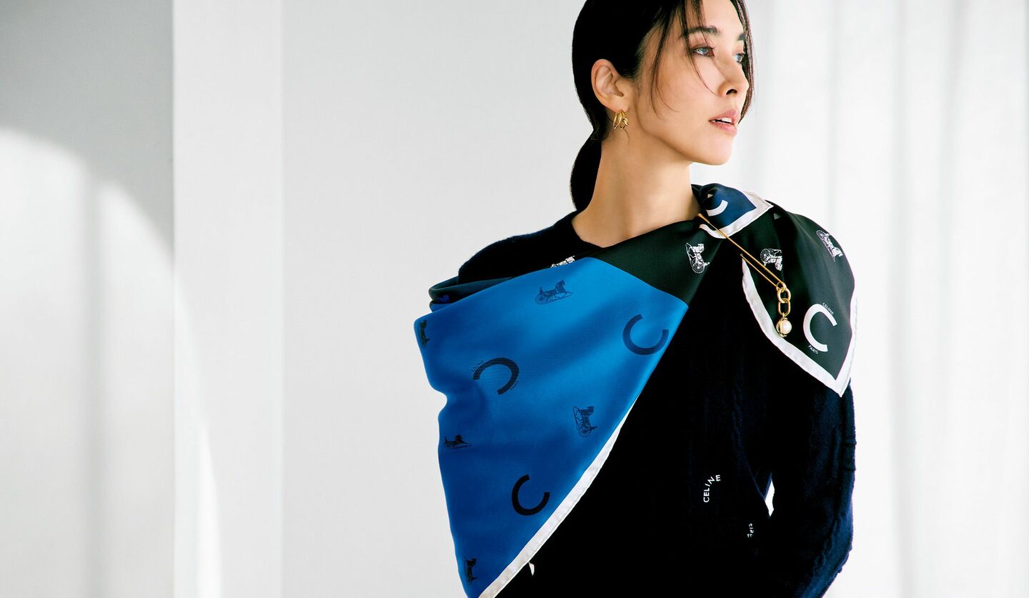 「セリーヌ」のスカーフをニットの上からアシンメトリーに巻いた着こなし