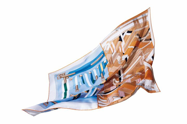 メゾンのルーツを象徴するサングル（乗馬用のバンド）を描いた2種類を組み合わせて、｢1枚の図案｣にアレンジ。左側は1985年に発表された図柄。ブルーを基調にした爽やかな配色が、スポーティーな雰囲気。右側の図柄は2017年に登場した｢ジグザグのサングル｣。ベージュ濃淡とピンクが優美な印象。カレ『ドゥブル・サングル』￥52,000【サイズ：90×90cm】［シルクツイル］（エルメスジャポン）