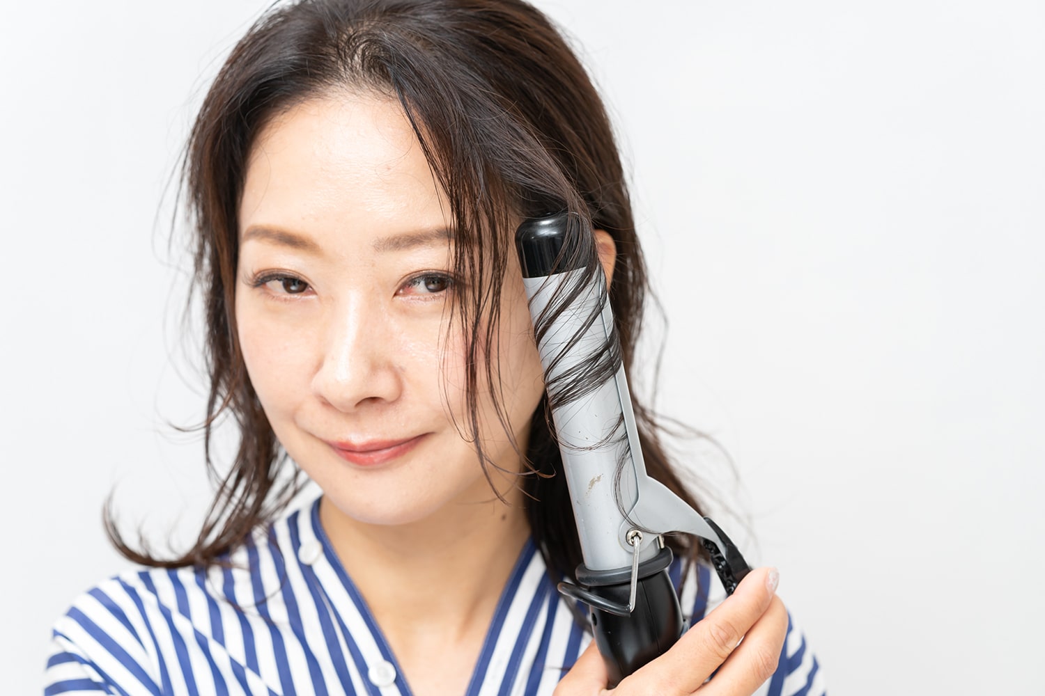 根元から毛先に向かって縦巻きになるように巻く。