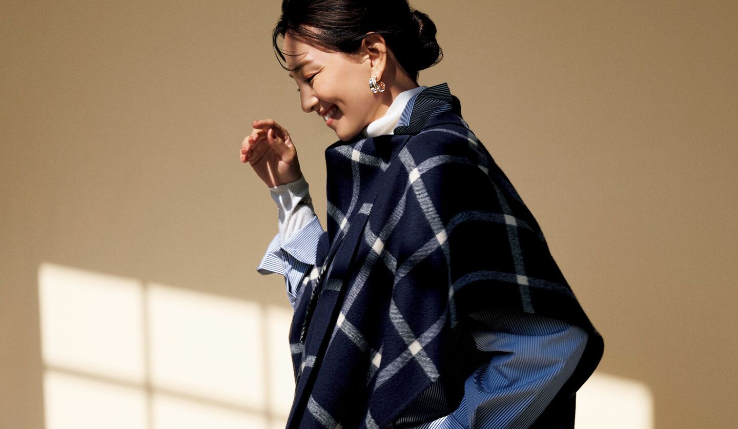 「ドゥロワー」のタートルニット、シャツ、ポンチョを着用したモデル