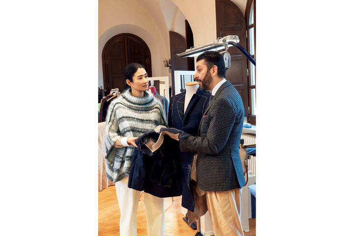 アントニオ先生は、卓越した技術を誇る紳士服の職人でもあります。「ぴしっと決めたジャケットスタイルも、かっこいいですね」と小雪さん。ポンチョ風ニット￥197,000・シャツ￥253,000・デニム［参考商品］（ブルネロ クチネリ ジャパン）