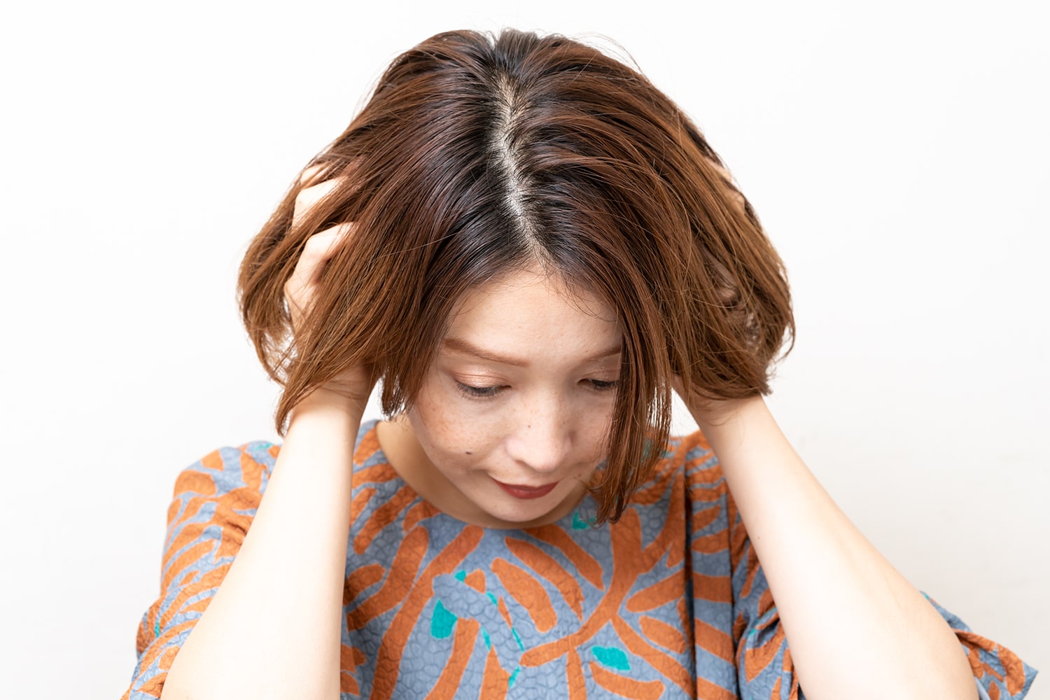 小指の爪くらいのシアバターを手のひらになじませて、耳後ろから揉みこむ。根元付近の内側からつけて、仕上げに表面や前髪を整えれば完成。