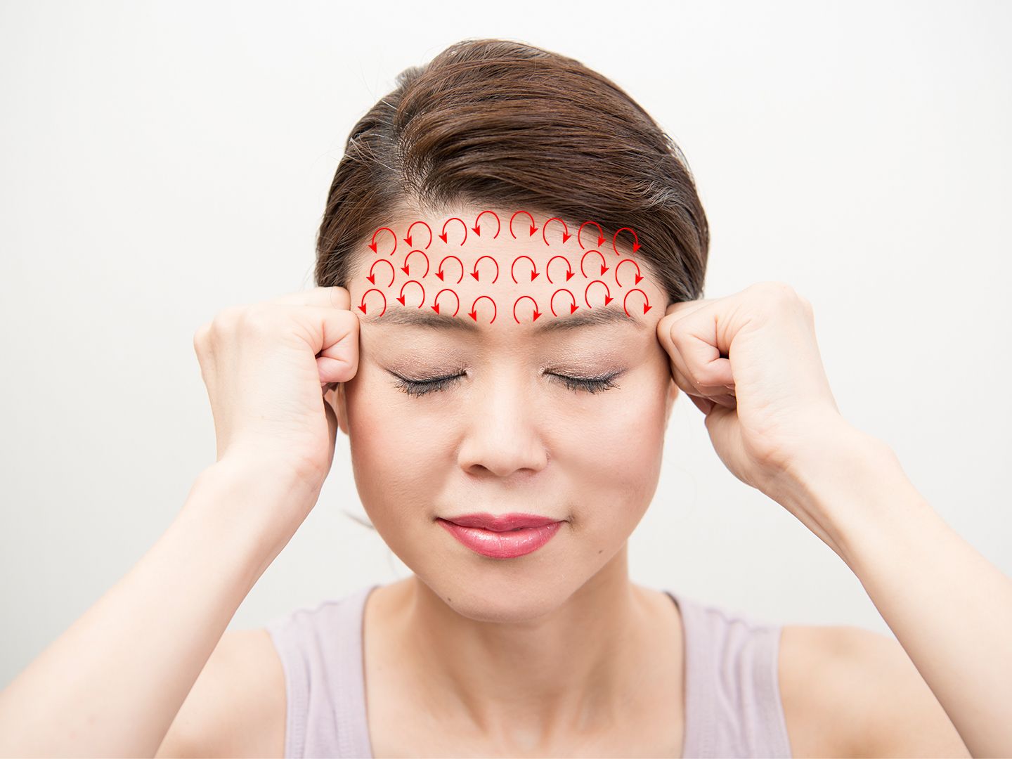 女性が額をマッサージしている様子