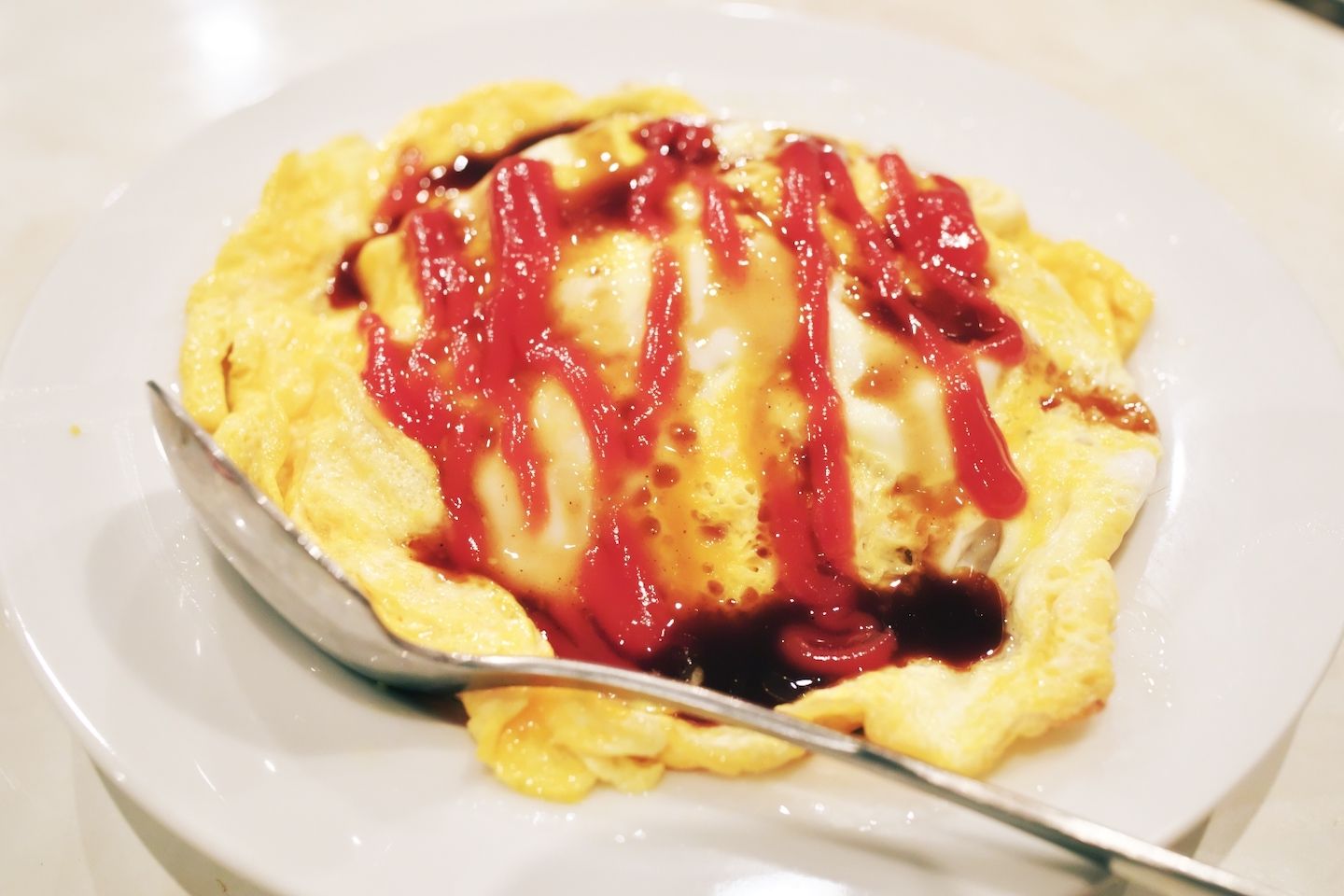 ケチャップとソースがかかった卵の中は、チキンライスではなく、ピラフ