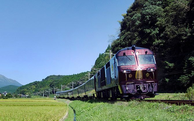 緑の中を自然とマッチした落ち着いたロイヤルワインレッドの列車が走ります ©JR九州