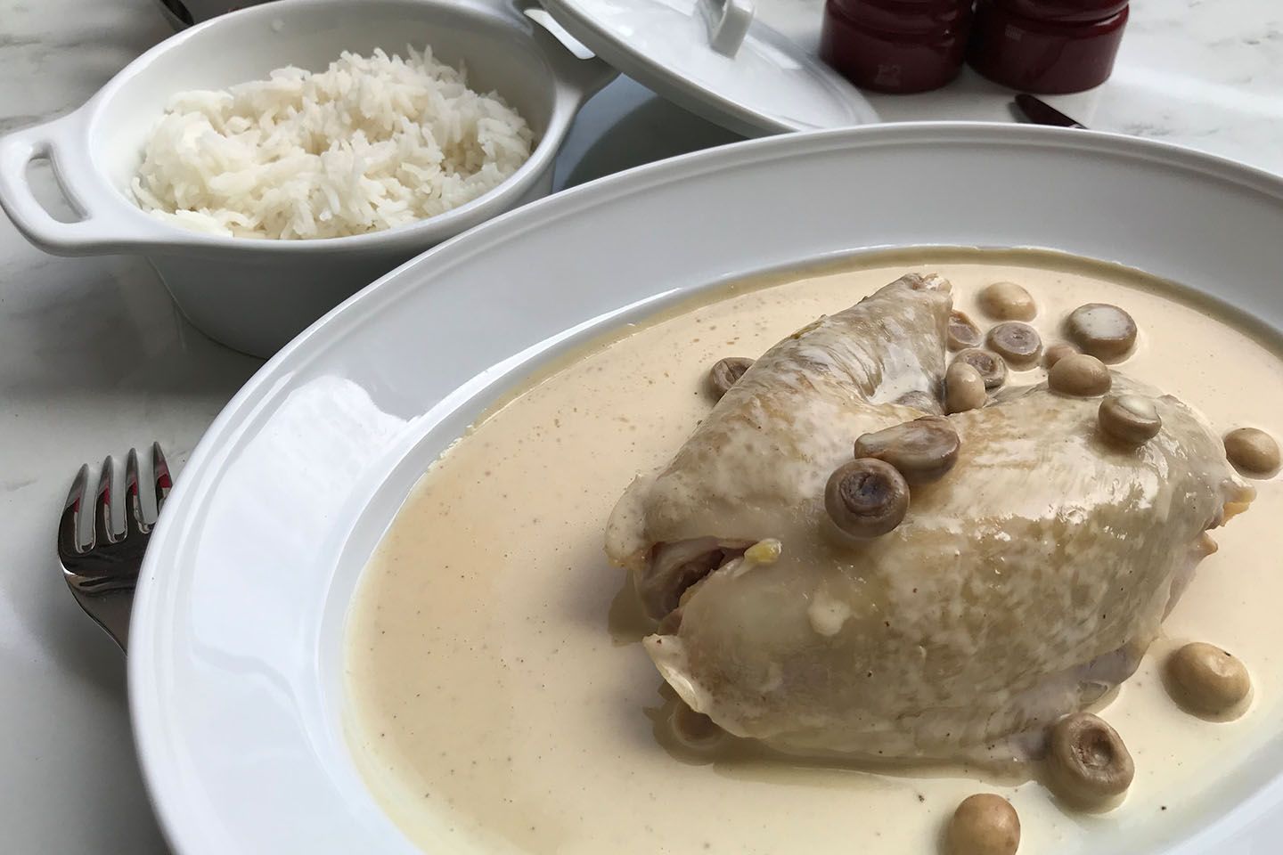 ボキューズの代表作のひとつ「ブレス産の鶏、マッシュルームとクリーム煮」€32。付け合わせのライスは皿に移して、鶏やクリームソースと一緒に絡めていただく。