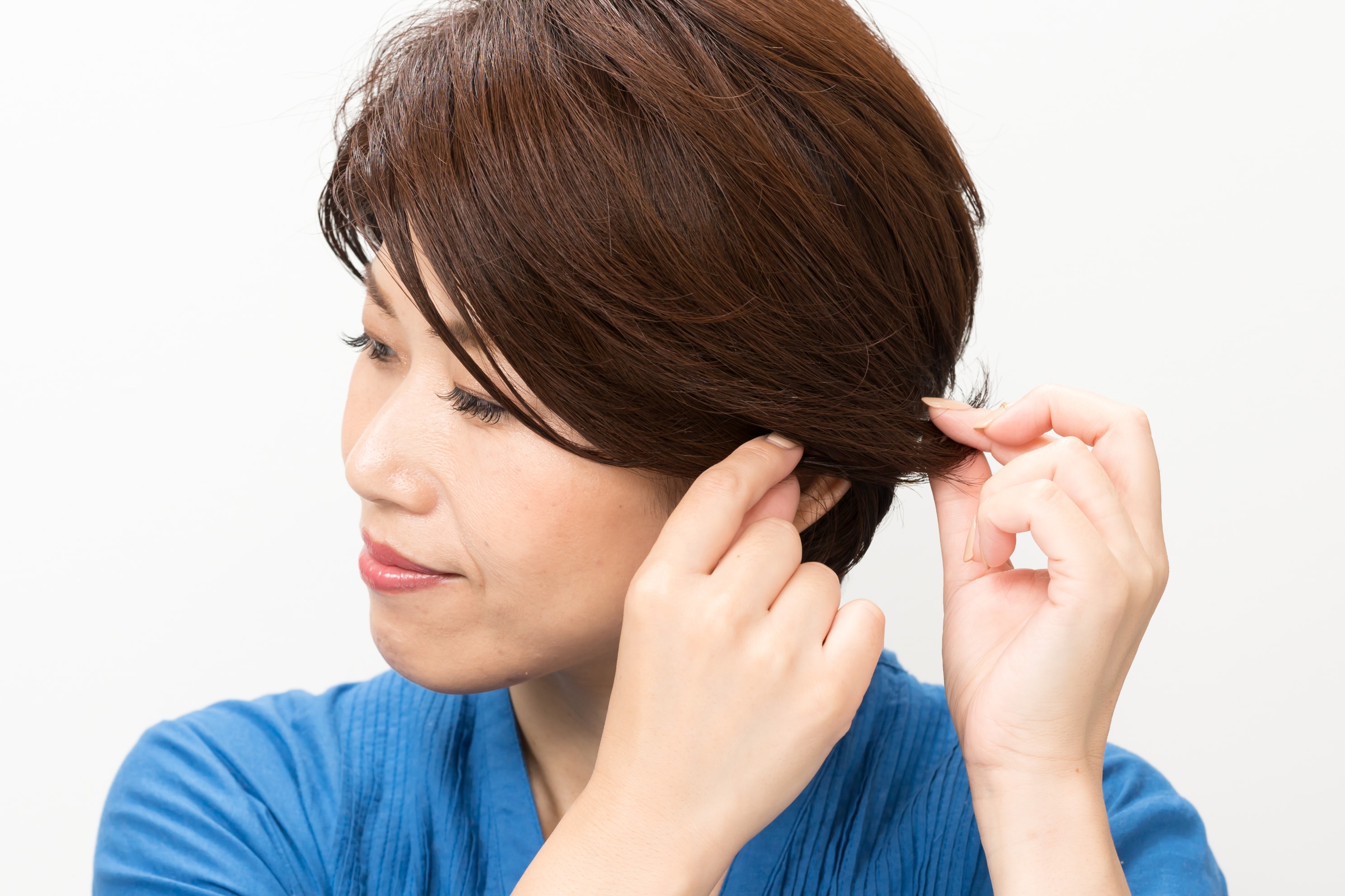 指先にワックスを取ったら、毛先をサイドに流すようになじませる。