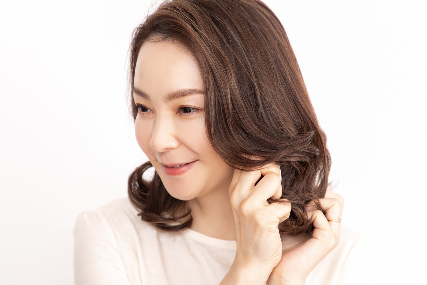 軽めのヘアワックスを手のひらにのばし、毛先にもみこんでツヤと束感を出す。