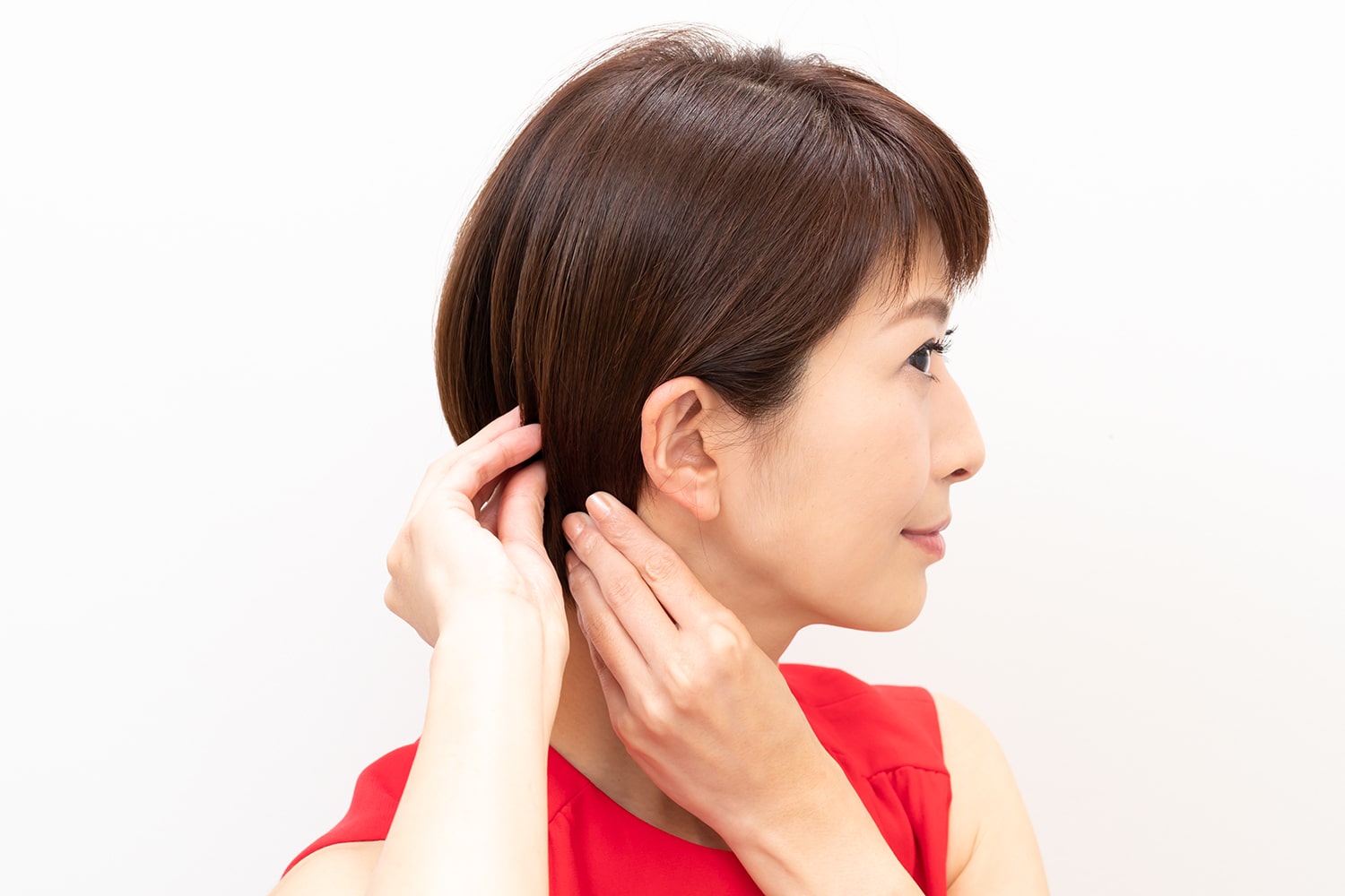 手指にワックスを広げ、サイドの髪を耳にかけるようにしてなじませる。