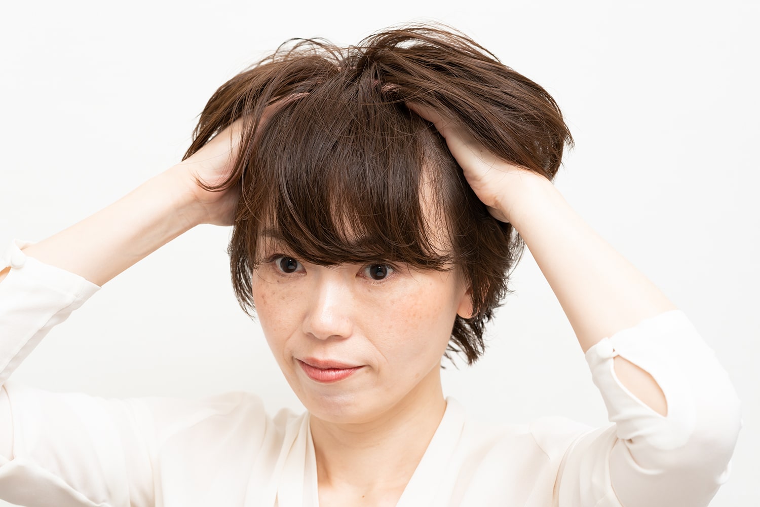 パール粒ひと粒大のワックスを手のひらになじませたら、髪の内側を握るように揉み込む。