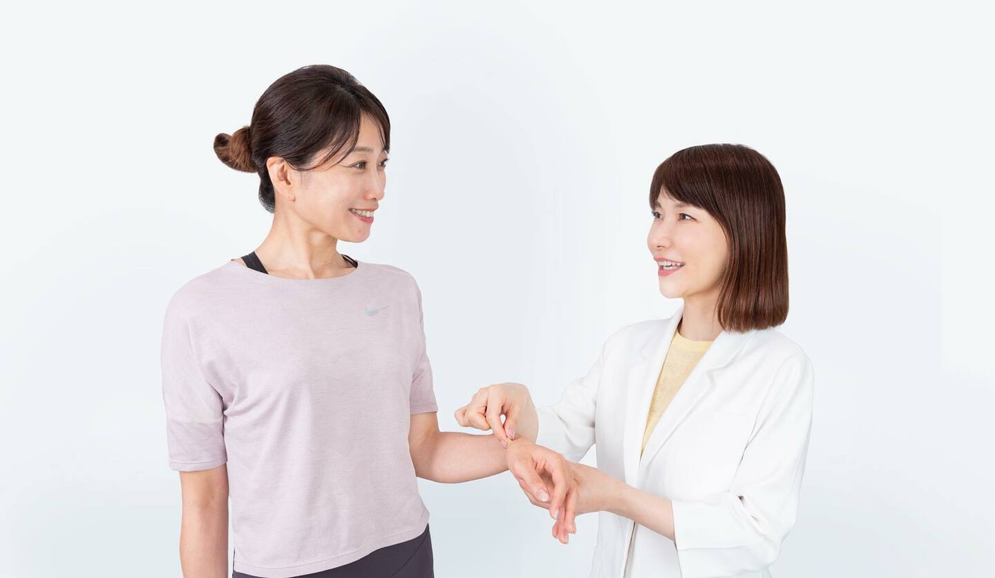 並んでいる二人の女性 筋膜リリースの指導をしている