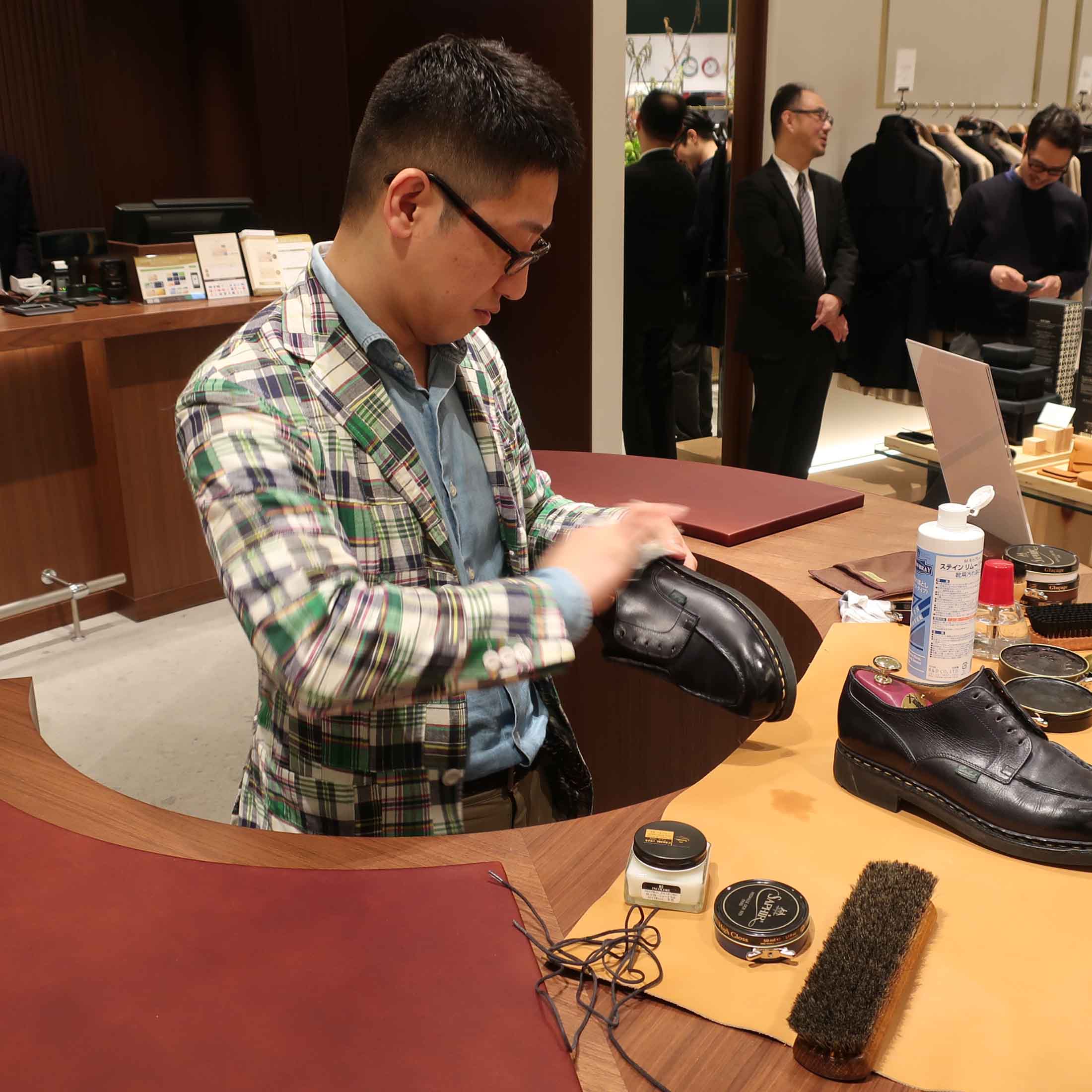店舗中央に設えられた円形のテーブルでポリッシュ作業を行うスタッフ。