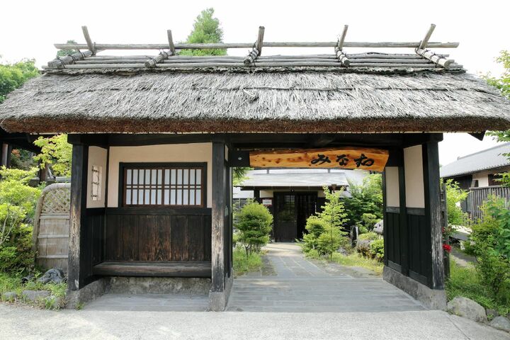 茅葺き屋根の門構えが、非日常の旅へと誘う。