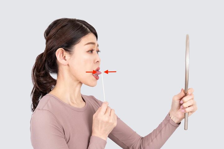 舌を前に出して割り箸と押し合う