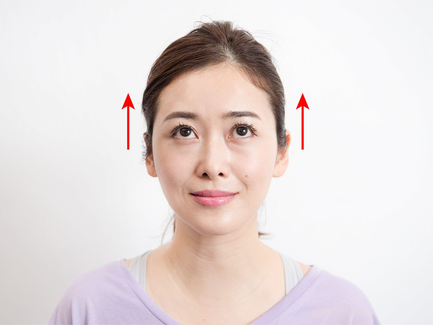 上方向に目を動かしている女性