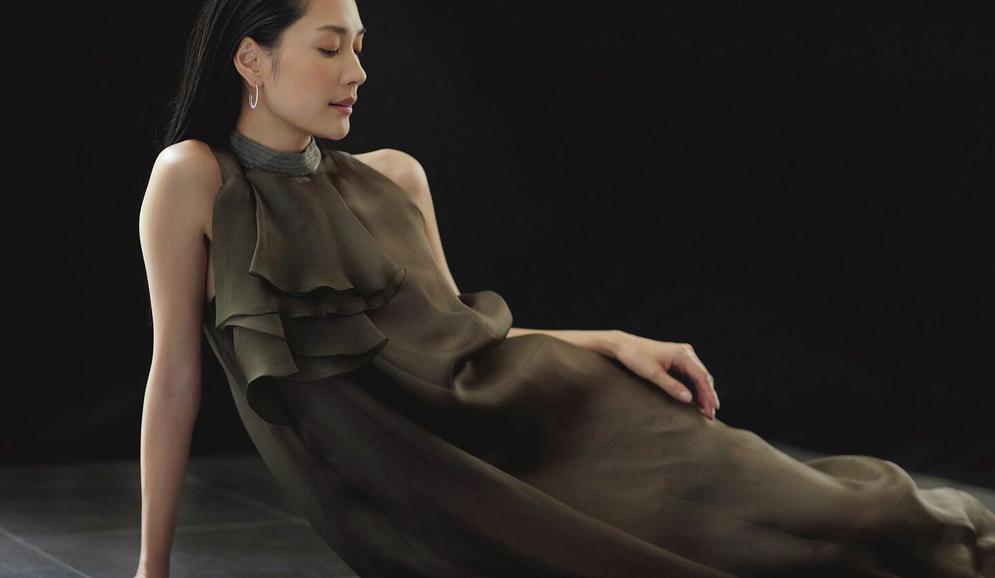 カーキブラウンのホルダーネックドレスを着たモデルの写真