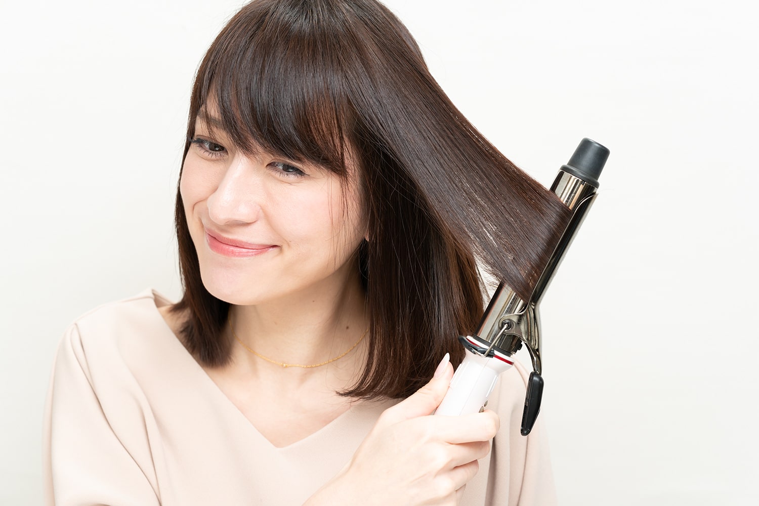 コテは32mmを使用。巻くというよりはさっと熱を通すように。毛束はざっくりと取ってOK。後頭部も同様に。