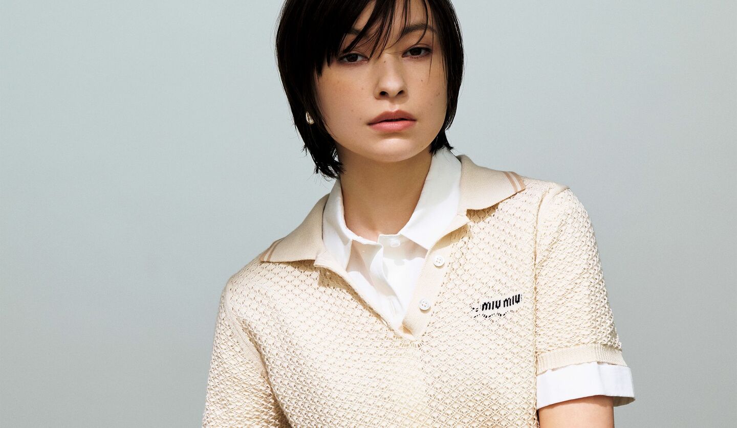 ミュウミュウのコットン素材の透かし柄編みポロニットを見るモデル太田莉菜さんの写真