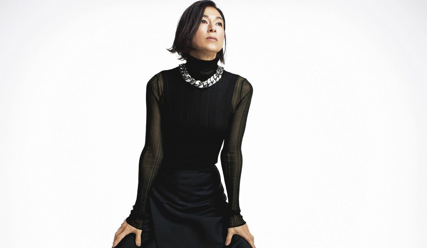 シアー素材のタートルネックに太いシルバーチェーンのネックレスをした鈴木保奈美さんの写真