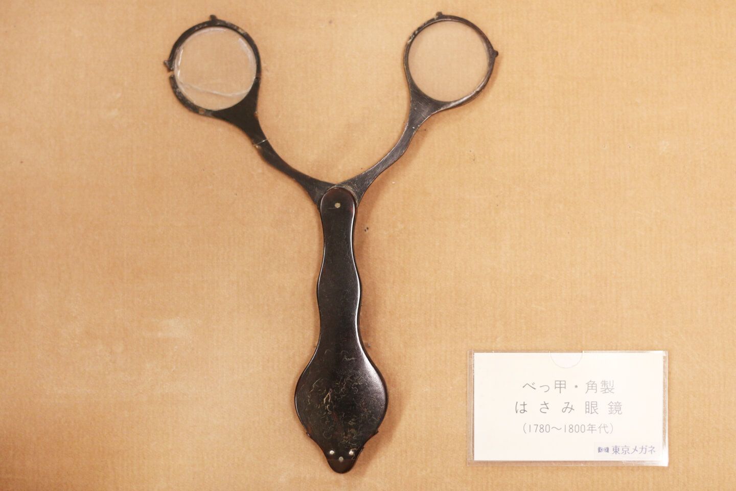 ハサミのようなメガネ。中心の柄をもち、顔の真正面にあてるのだとか