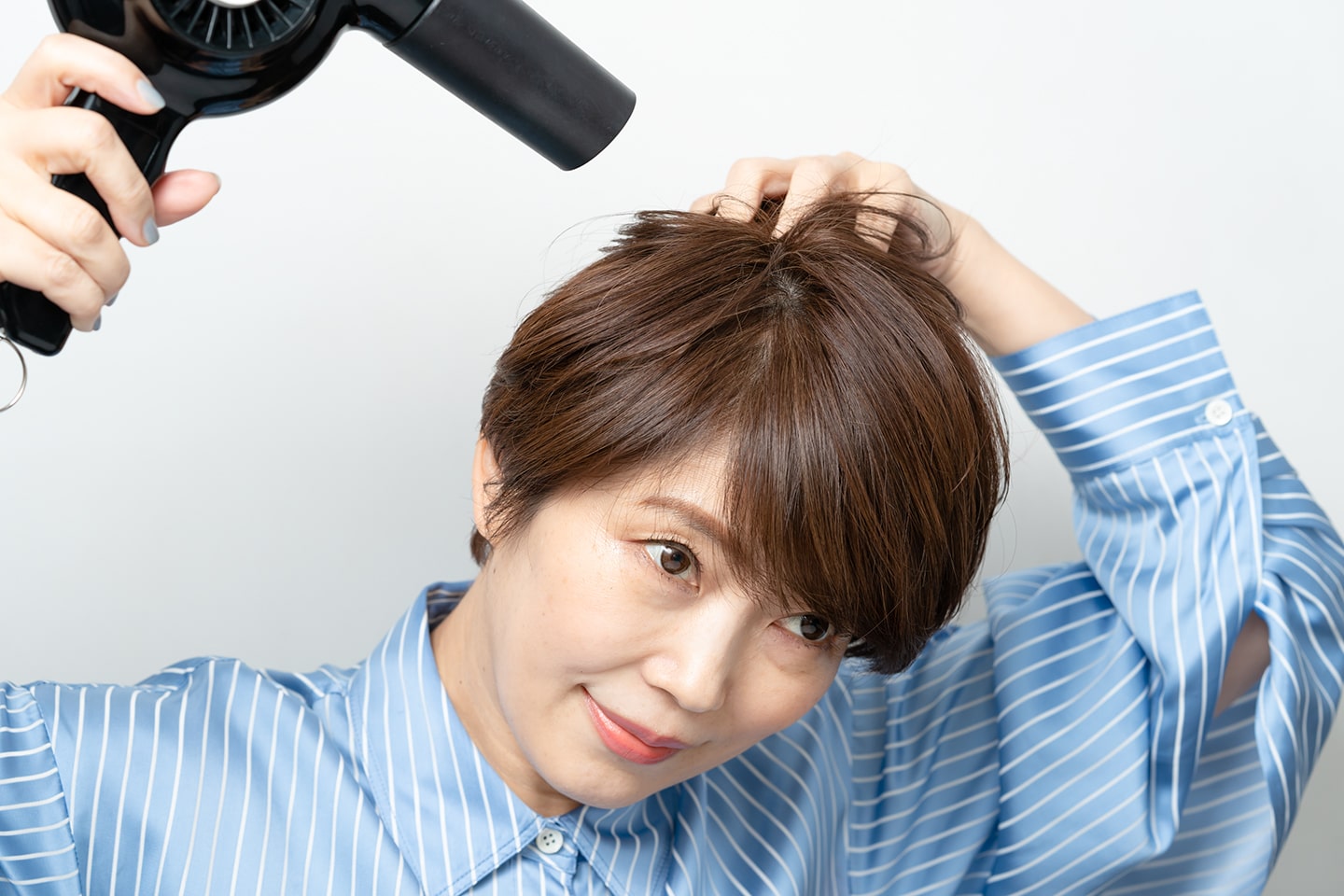 指の腹で頭皮を擦りながらドライヤーをあて、毛穴の向きをニュートラルに戻す。