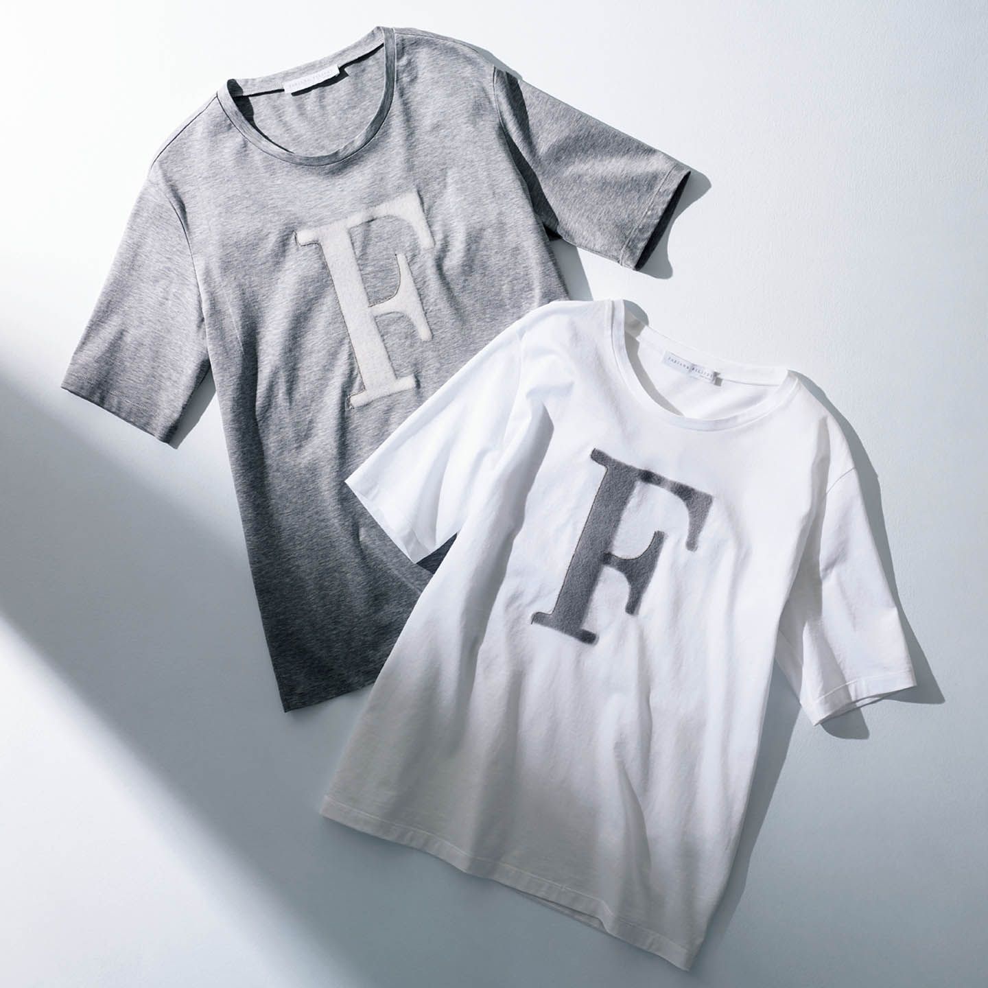 起毛素材を使用した「F」ロゴには、職人が手作業でていねいに施した「ルーチェ」の輝きがプラス。Tシャツ左から/グレー、白 各¥38,000(アオイ〈ファビアナフィリッピ〉)