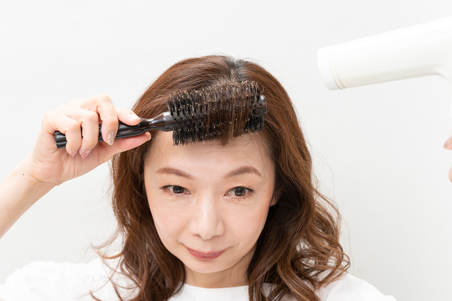 ロールブラシで内巻きにし、根元にドライヤーをあてる
